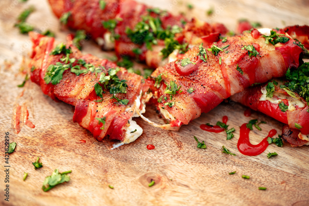 Sweet red pepper stuffed with cream cheese, wrapped in bacon and grilled Sweet red pepper stuffed with cream cheese, wrapped in bacon and grilled