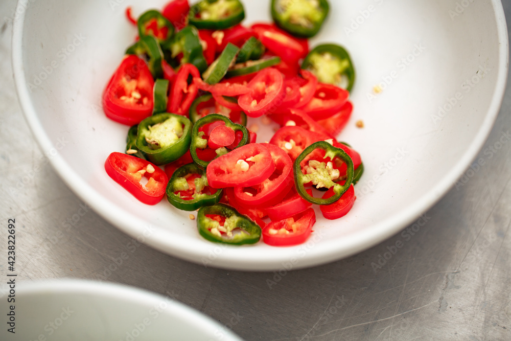Bowl of sliced chilli peppers - red and green Bowl of sliced chilli peppers - red and green