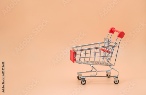 shopping cart empty with copy space on beige background