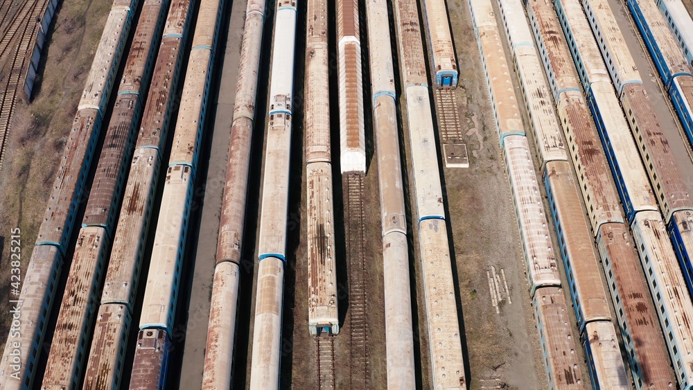 Railway hub showing passenger old crusty trains on tracks next to each other top down view drone moving slowly showing railway tracks positioned parallel. Old Railway Carriages and Wagons 4k 