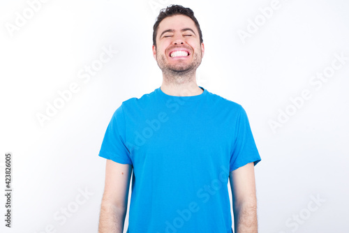 young handsome caucasian man wearing blue t-shirt against white background very happy and excited about new plans.