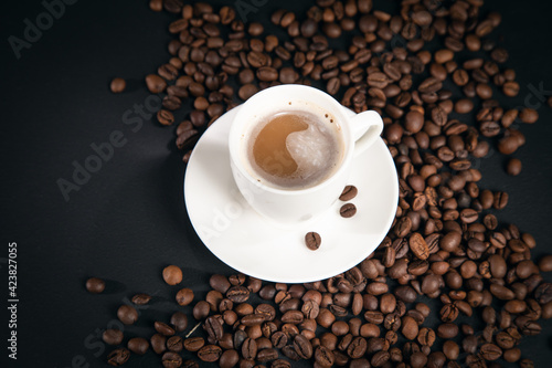 cup of coffee with coffee beans on black background