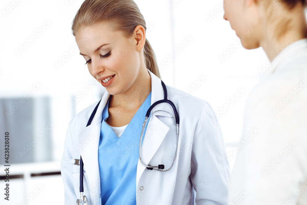 Woman - doctor consults her female patient while using clipboard and medication history record. Medicine concept Woman - doctor consults her female patient while using clipboard and medication history record. Medicine concept