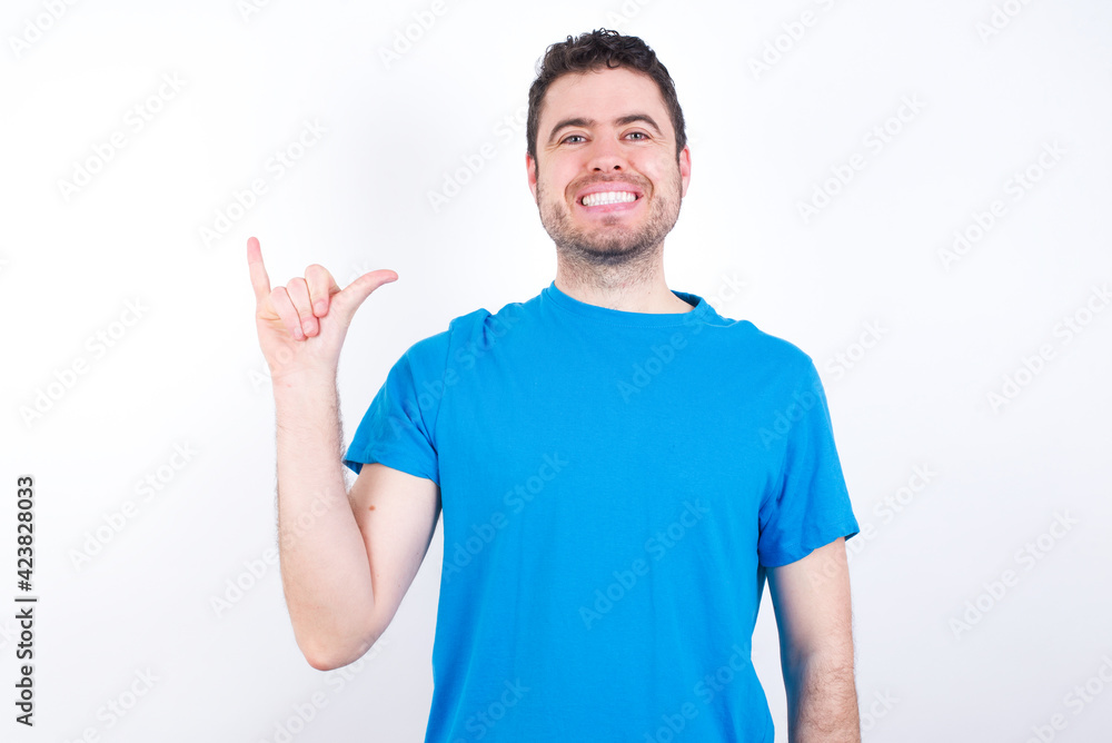 young handsome caucasian man wearing blue t-shirt against white background showing up number six Liu with fingers gesture in sign Chinese language young handsome caucasian man wearing blue t-shirt against white background showing up number six Liu with fingers gesture in sign Chinese language