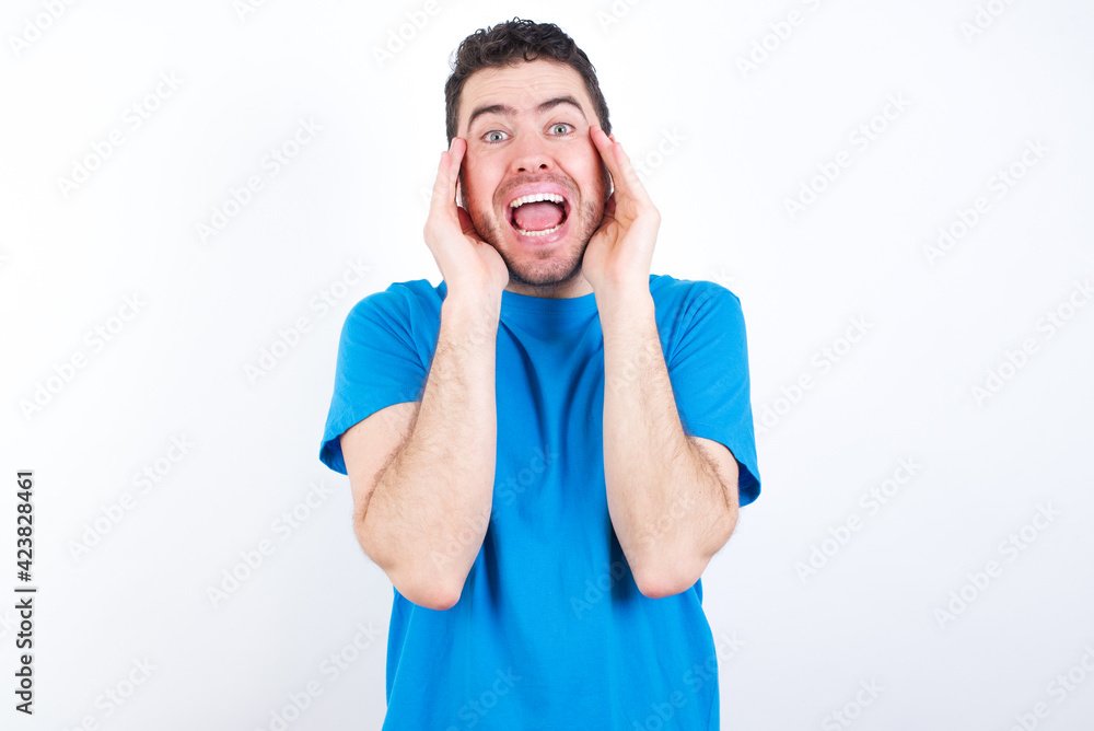 young handsome caucasian man wearing white t-shirt against white background Pleasant looking cheerful, Happy reaction young handsome caucasian man wearing white t-shirt against white background Pleasant looking cheerful, Happy reaction
