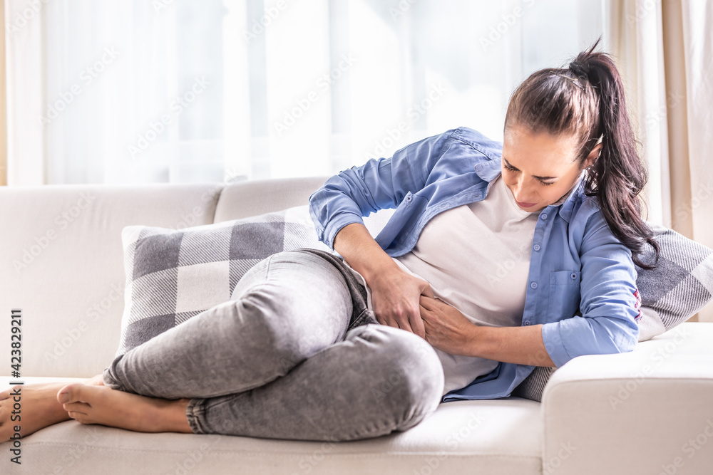 Detail of a woman in pain of abdominals, gallbladder, ovaries, appendix, liver or intestines holding belly with hands Detail of a woman in pain of abdominals, gallbladder, ovaries, appendix, liver or intestines holding belly with hands