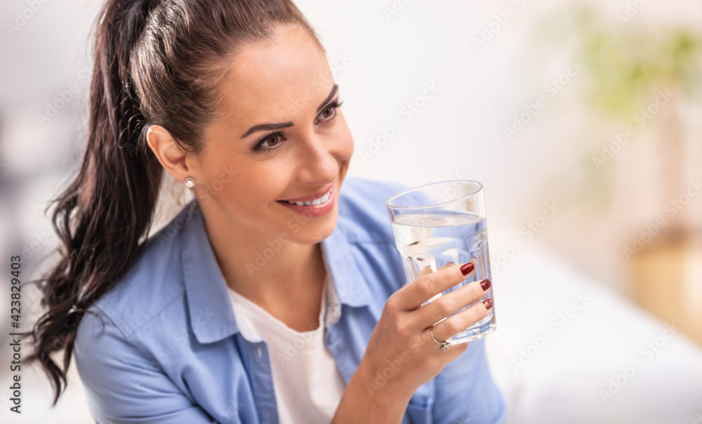 Smiling girl holds a glass of pure water in her hand Smiling girl holds a glass of pure water in her hand