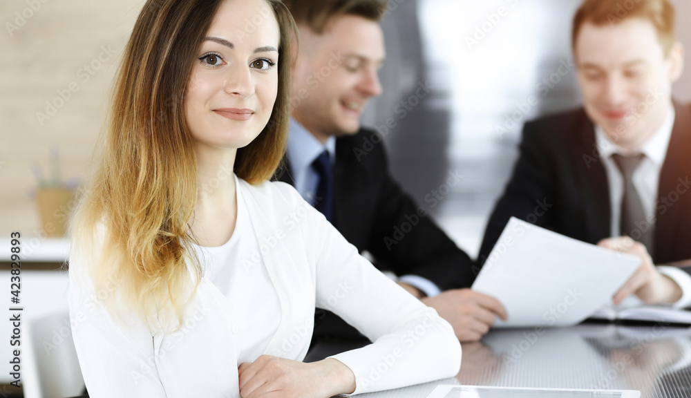 Business woman headshot in sunny office. Unknown businesswoman sitting behind computer monitor Business woman headshot in sunny office. Unknown businesswoman sitting behind computer monitor