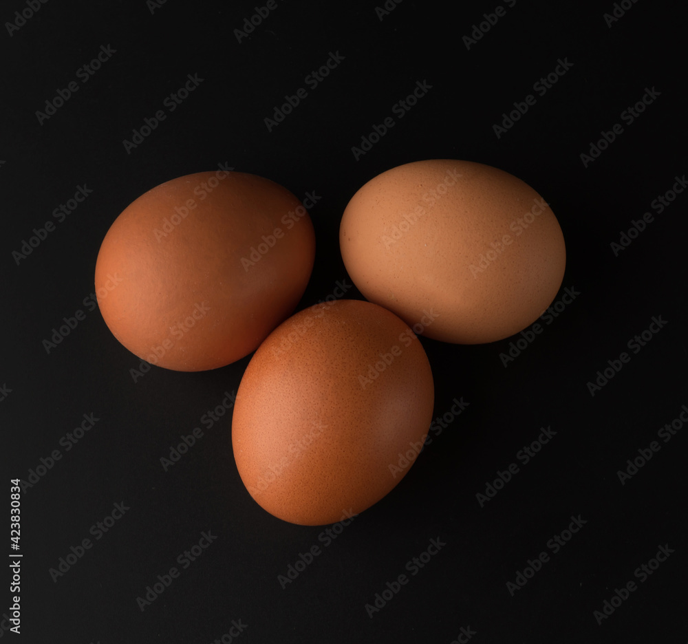Chicken eggs with brown shell on black background Chicken eggs with brown shell on black background