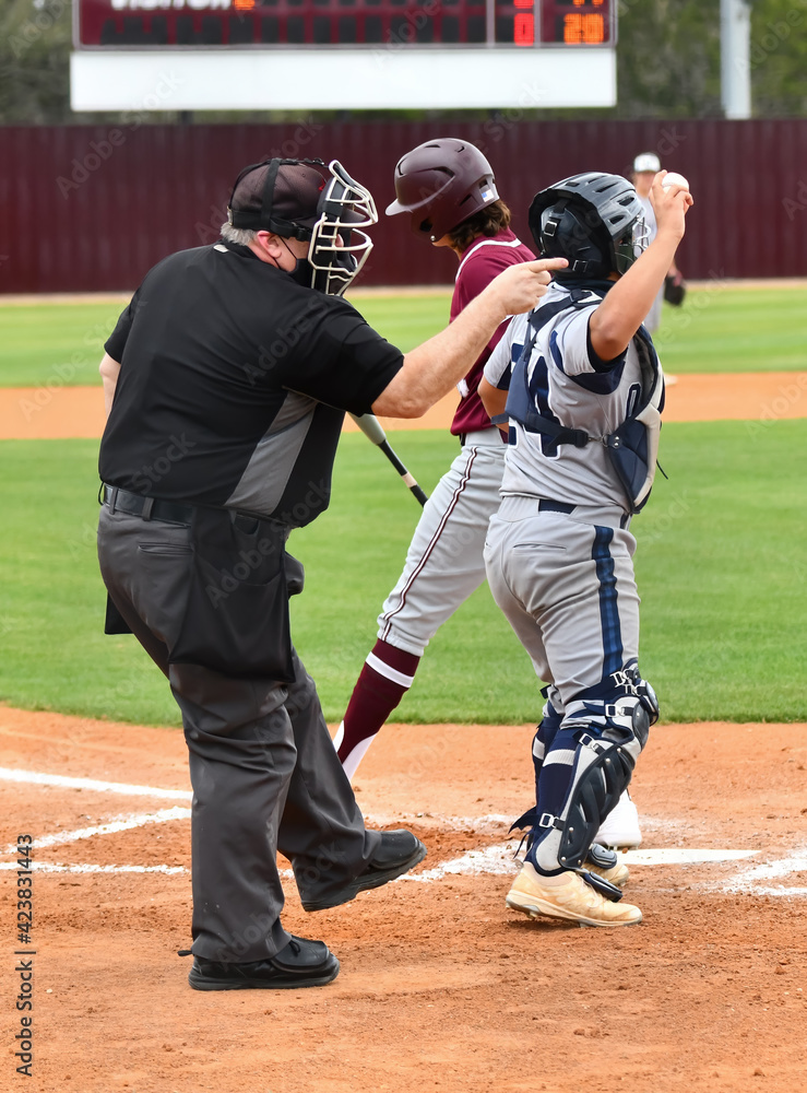 Baseball umpire calling balls and strikes at the plate and keeping the