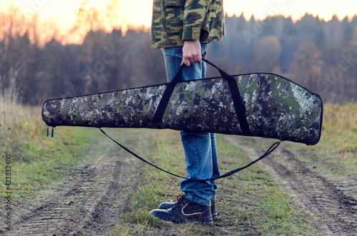hunter, shooter with a rifle hidden in a case