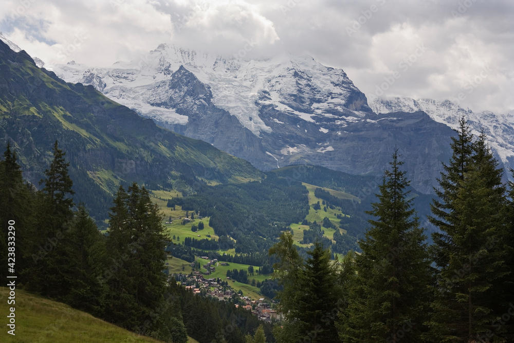 Clouds over the Jungfrau and its glacier (the Giesengletscher), with the village of Wengen below: Bernese Oberland, Switzerland