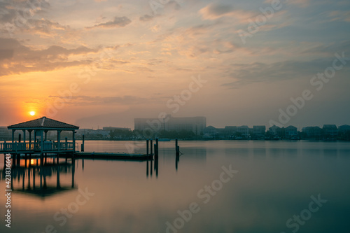 The sun rises over a private dock on Harbor Island while the buildings of Lumina Avenue are still obscured by morning mist. Space for copy