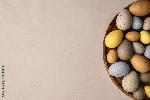 Easter holidays flatlay with natural pastel colored eggs on a linen table cloth