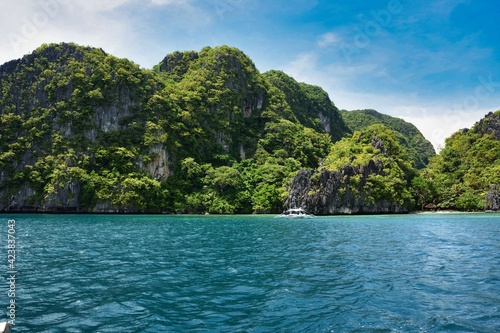 El Nido Palawan dive spot in the Philippines, Island hopping, rock in the ocean, blue cloudy sky, fantastic view, sun
