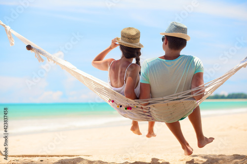 Young romantic couple relaxing in hammock on tropical beach in Thailand