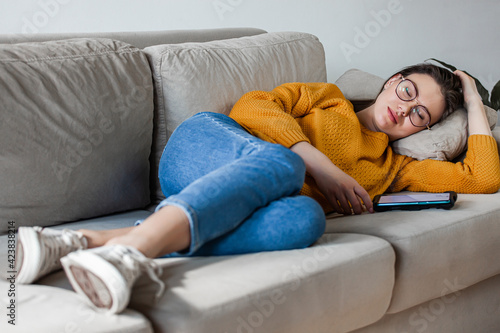Young woman sleep on sofa using mobile phone