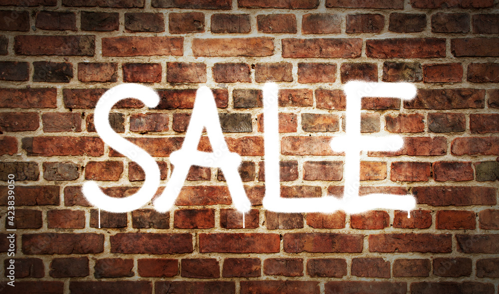 Sale sign spray painted on the brick wall Sale sign spray painted on the brick wall