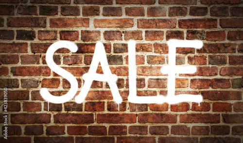 Sale sign spray painted on the brick wall