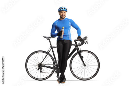 Male cyclist sitting on a bicycle with a bottle in his hands