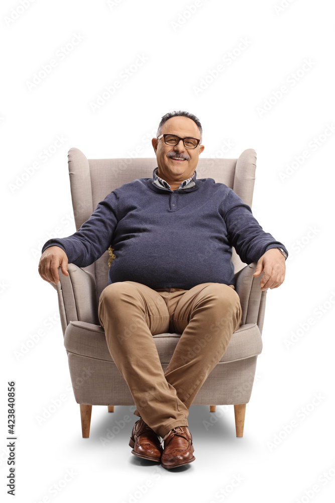 Happy mature man sitting in an armchair and smiling Happy mature man sitting in an armchair and smiling