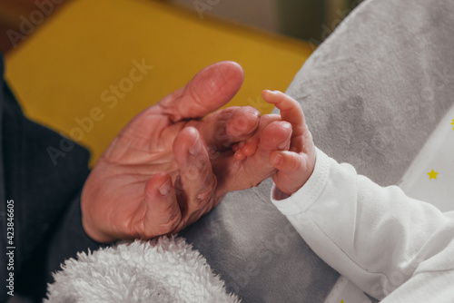 Grandmother hand holding her grandson hand