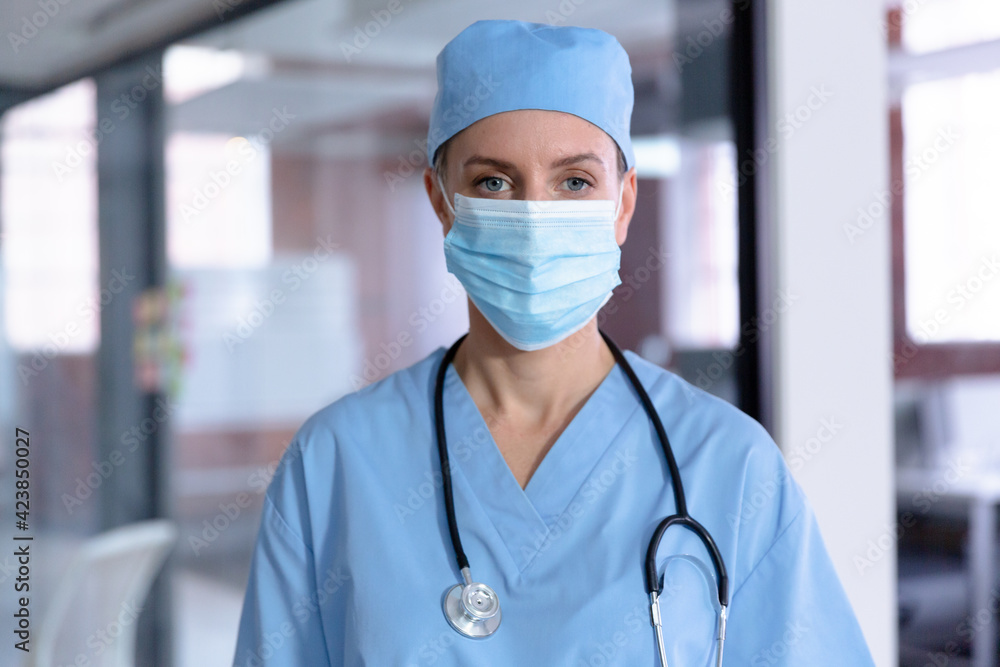 Portrait of caucasian female doctor wearing face mask, scrubs and stethoscope Portrait of caucasian female doctor wearing face mask, scrubs and stethoscope