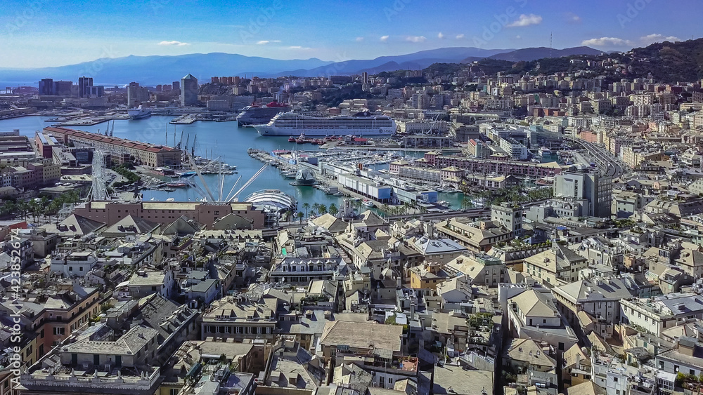 Fototapeta premium Aerial panoramic drone view of buildings and streets surrounding Port of Genoa.Cruise ship in port.