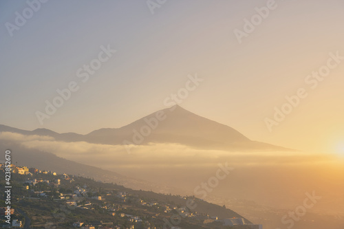 View of Teide at sunset with calima with a village on the hillside. travel destination