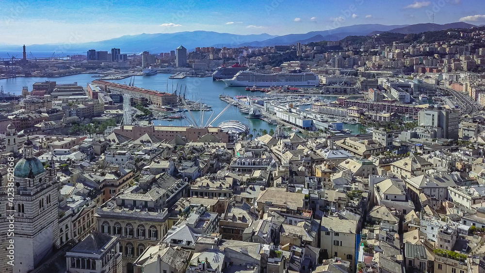 Aerial panoramic drone view of buildings and streets surrounding Port of Genoa.Cruise ship in port.