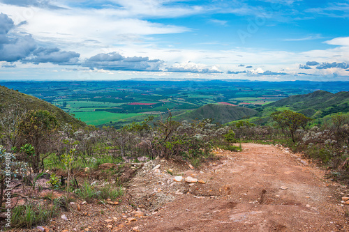 Dirt road on top of a hill with a view to brazilian farms and fields. Beautiful landscape view of MG-341 road at São Roque de Minas, MG, Minas Gerais - Brazil. photo