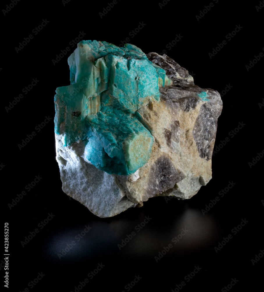 Bright green plagioclase amazonite mineral crystals and morion smoky quartz blotches in rock mineral rock isolated on black background. From Volodar Volynsky, Ukraine Bright green plagioclase amazonite mineral crystals and morion smoky quartz blotches in rock mineral rock isolated on black background. From Volodar Volynsky, Ukraine