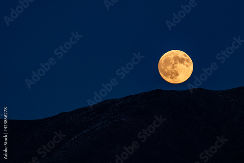 USA, Idaho, Bellevue, Full moon rising over hills photo