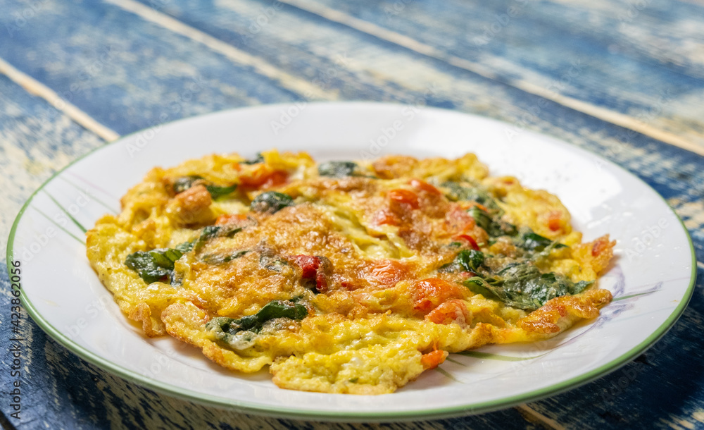 Thai egg omelette or locally known as Kai Chiao over wooden background. Selective focus. Thai egg omelette or locally known as Kai Chiao over wooden background. Selective focus.