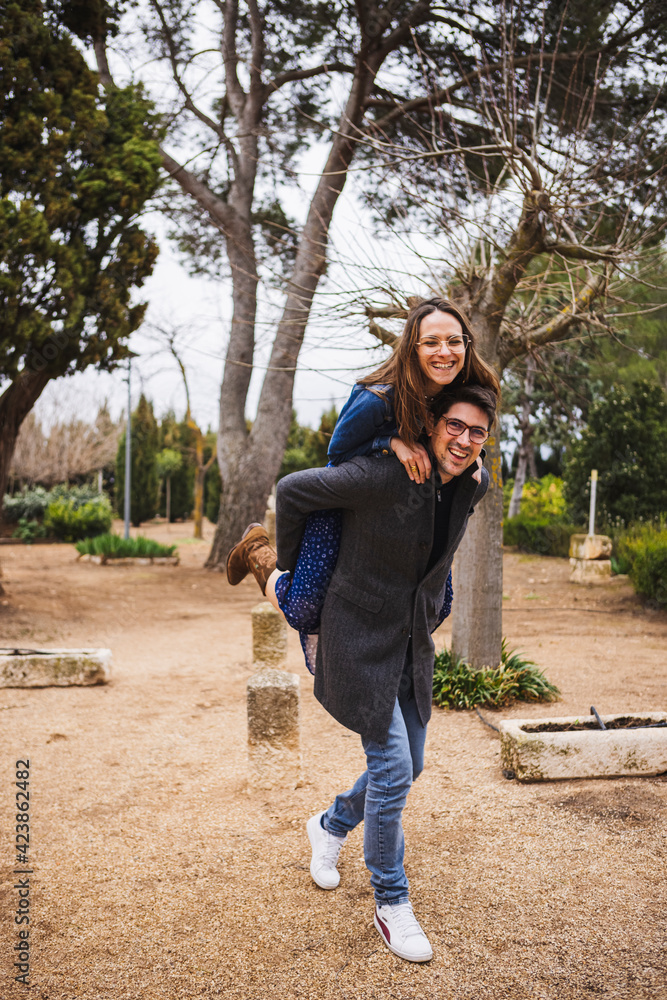 Young girl climb on the back of her boyfriend, piggyback, having fun Young girl climb on the back of her boyfriend, piggyback, having fun