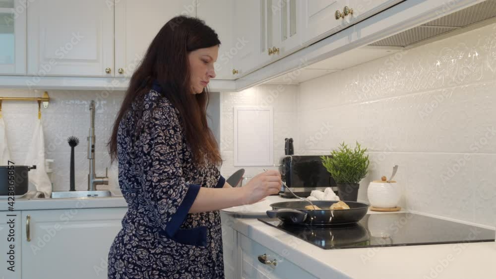 Woman cooking dinner frying Smelt koryushka fish in a frying pan in modern kitchen at home, koryushka rolled in wheat flour and gently fried. High quality 4k footage Woman cooking dinner frying Smelt koryushka fish in a frying pan in modern kitchen at home, koryushka rolled in wheat flour and gently fried. High quality 4k footage