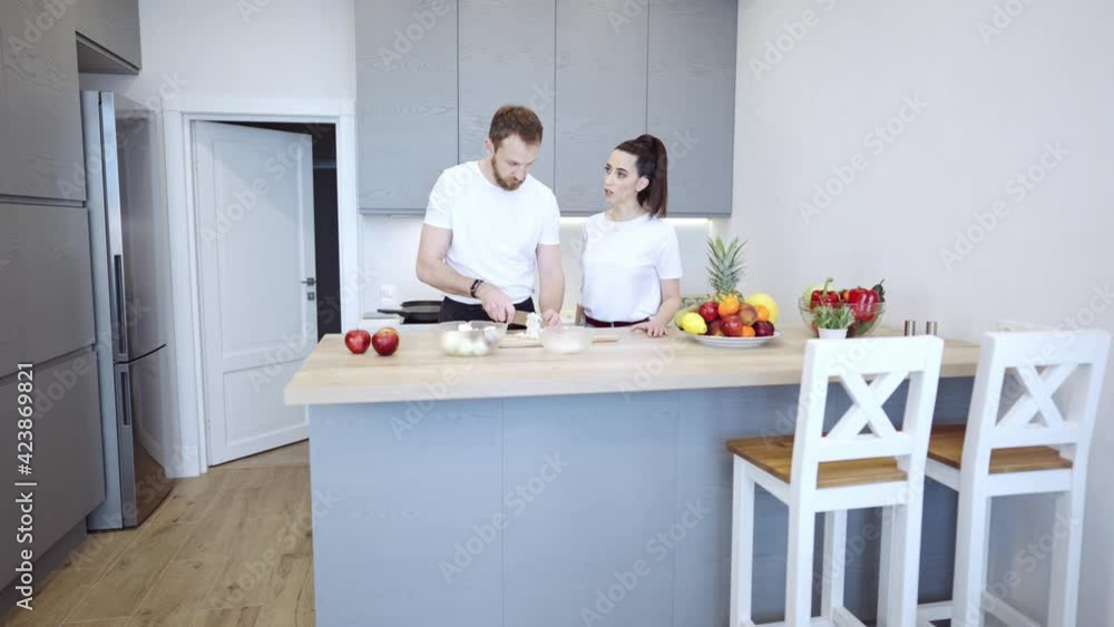 Couple Cooking Together At Home In The Kitchen Young cheerful couple cooking together at home in the kitchen. Healthy food diet and nutrition. Couple Cooking Together At Home In The Kitchen Young cheerful couple cooking together at home in the kitchen. Healthy food diet and nutrition.