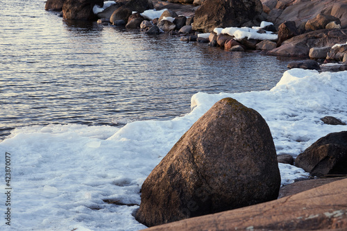 The stone coast of the Baltic Sea in spring with the remains of ice. photo