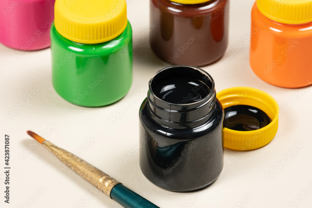open gouache paint glass with other tubes in the background open gouache paint glass with other tubes in the background