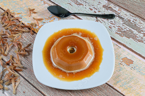 Dulce de leche pudding with caramel syrup, alongside flying seeds (Triplaris americana). A traditional Brazilian sweet. photo