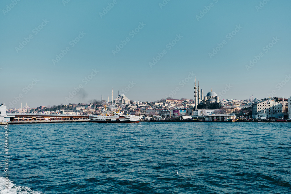 Turkey istanbul 03.03.2021. Yeni Cami mosque in istanbul turkey during morning with seagulls. Galata bridge corner and pedestrian ferry in istanbul bosphorus early in the morning.