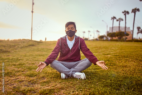 Hombre joven descansa en un parque durante un atardecer de verano.  Joven haciendo yoga en un parque © alex fernandezch