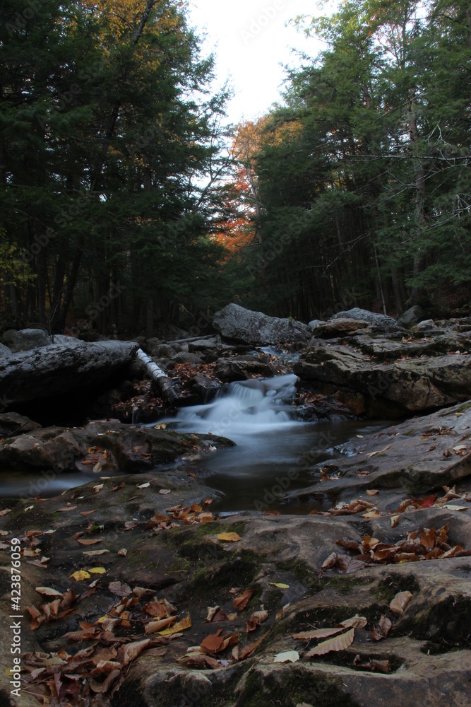 autumn waterfall flowing through mountain creek autumn waterfall flowing through mountain creek