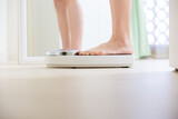 woman stand on weight scale