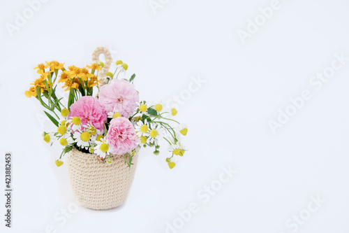 Beautiful color of flower in crochet hanging planter isolated on white background. © swisty242