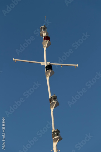 The mast of a modern ship against the background of the blue sky.