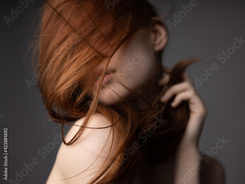 Red hair silk model gray background naked shoulders passionate look