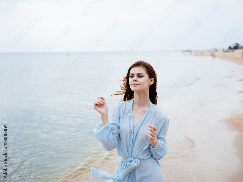 Happy red-haired woman running along the ocean on the beach cropped view Happy red-haired woman running along the ocean on the beach cropped view