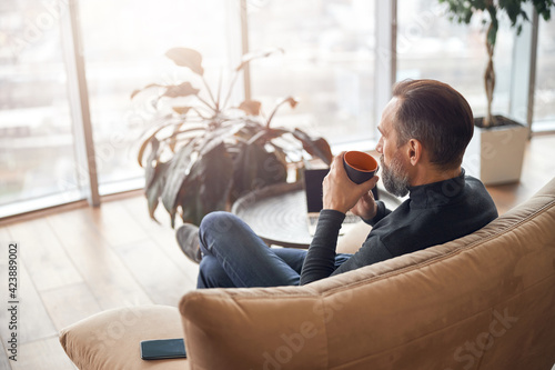 Happy adult caucasian man is working in a modern office