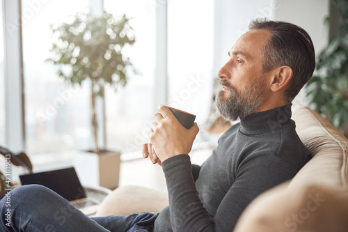 Happy adult caucasian man is working in a modern office